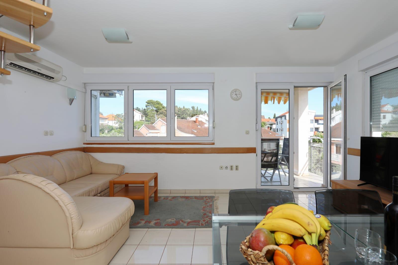 Apartman Gumbek — svijetli dnevni boravak s kožnom garniturom i izlazom na balkon