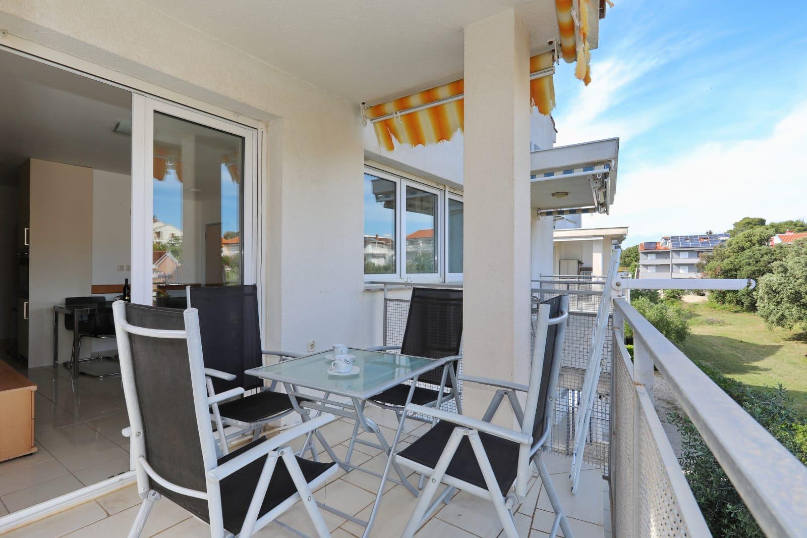 Apartman Gumbek — balkon s tendom, stolom i četiri stolice
